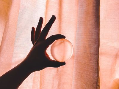Hands holding a smooth wooden exercise ball